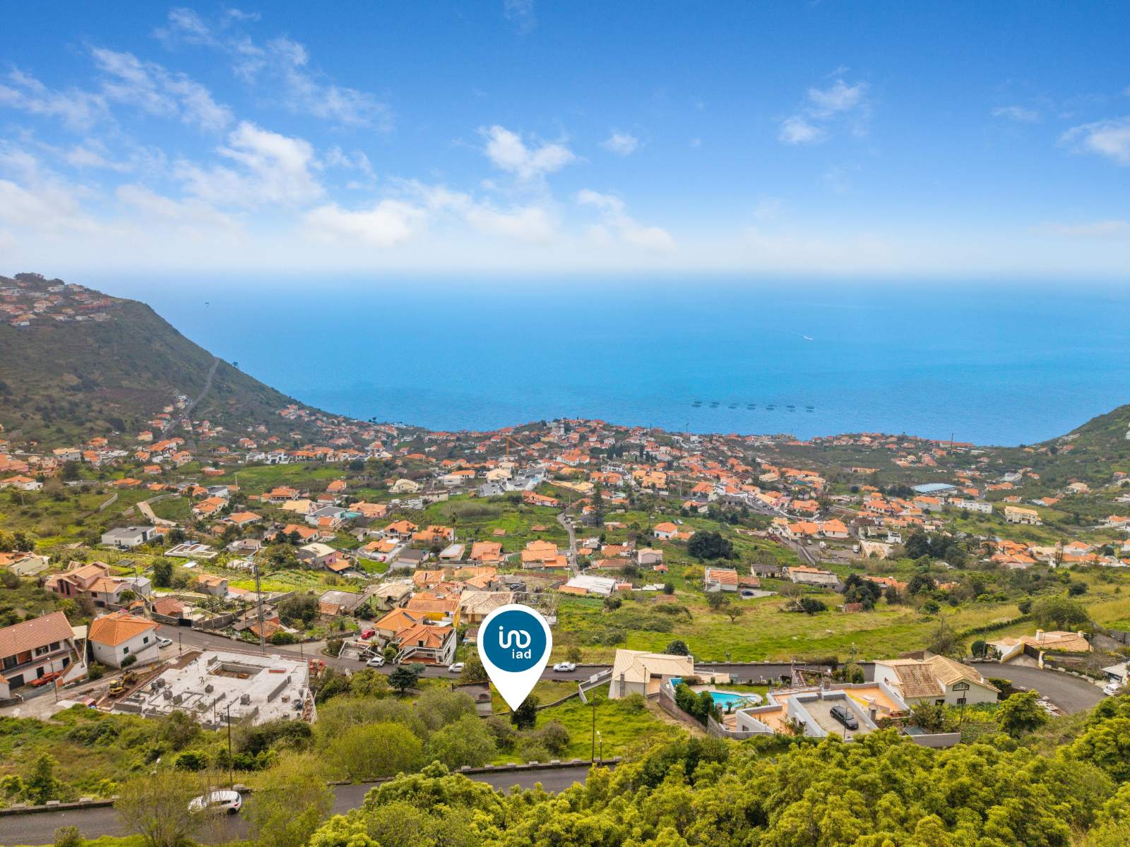 Aerial view toward the coast from above the plot, marked by the listing agency's location pin