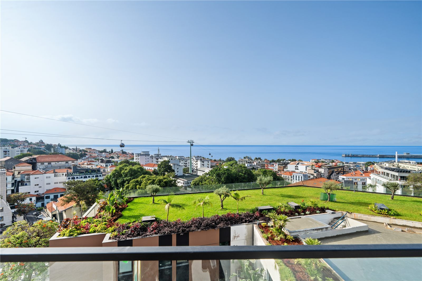 View from a planted roof terrace across Funchal rooftops to the harbour and the open Atlantic
