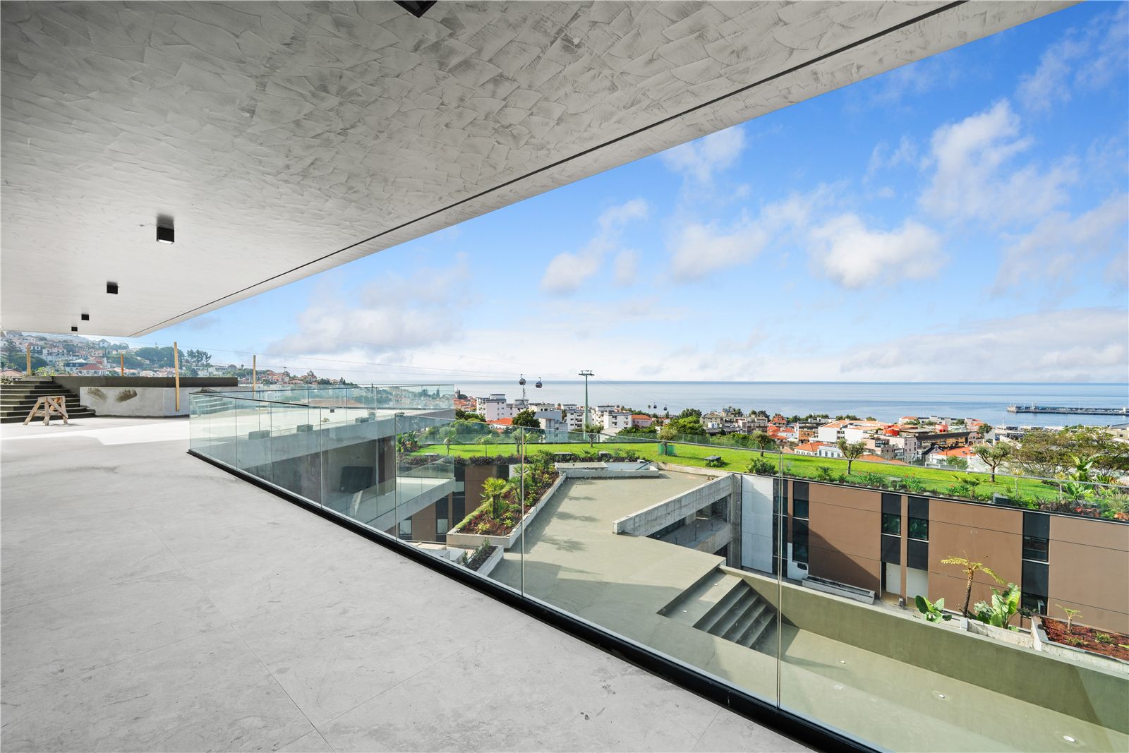 Looking down from the terrace over the planted roof gardens of the block below towards the sea