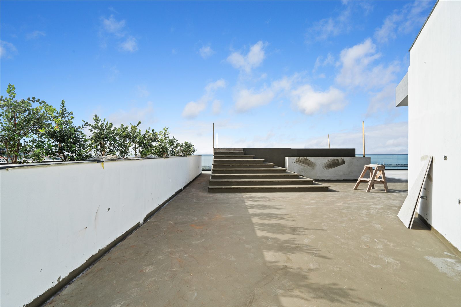 The flat roof terrace with a low parapet wall and the sea beyond