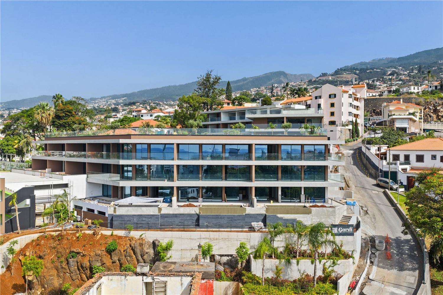 The development from the air at a lower angle, showing the stepped balconies and the planted roof