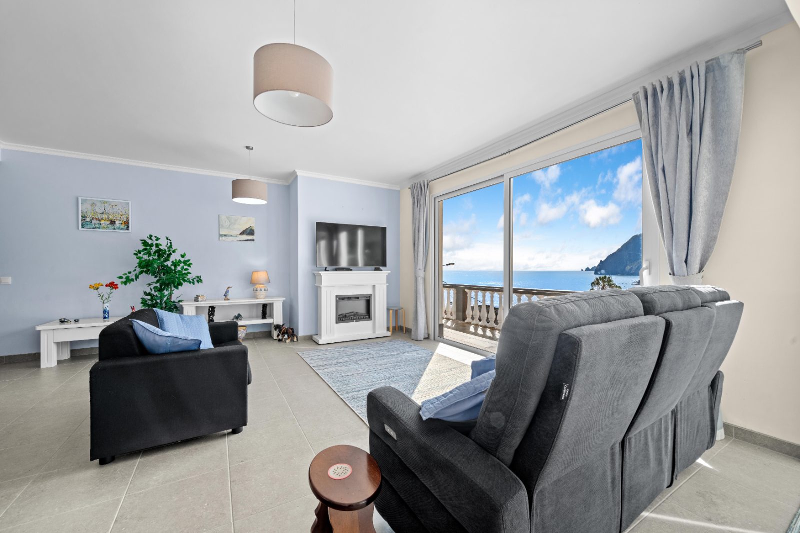 Living room with a window onto the open sea and a rocky headland, Porto da Cruz
