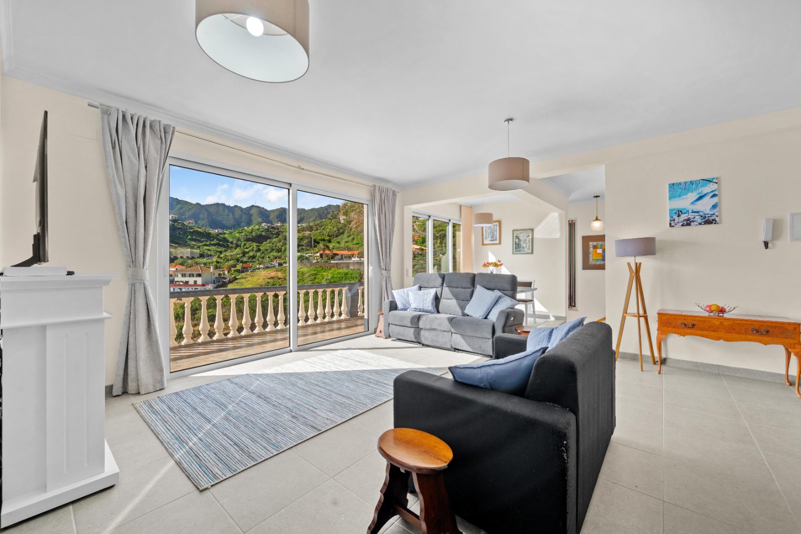 Living room with a window onto green hillsides and the houses of the valley, Porto da Cruz