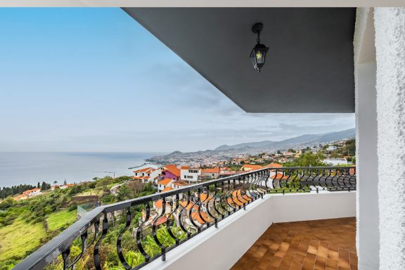 The view from under the terrace roof across terracotta rooftops to the bay