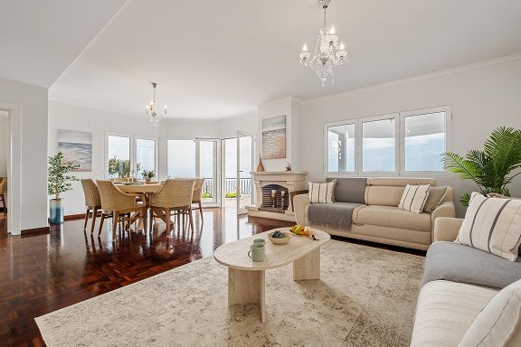 Living room with sofas and a fireplace, the dining area beyond