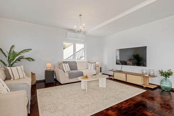 Second sitting area with sofas and a wall-mounted television