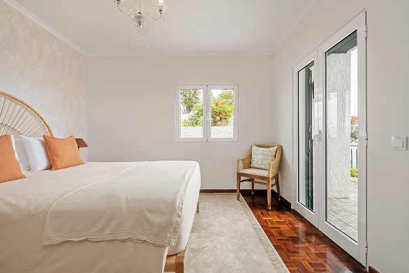 Bedroom with doors onto the terrace and a window to the hillside