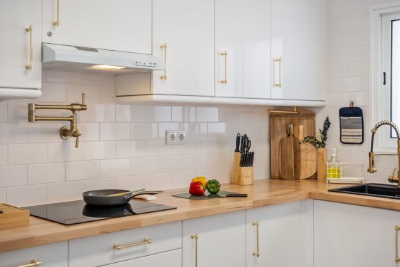 Kitchen with white units, a wooden worktop and an induction hob