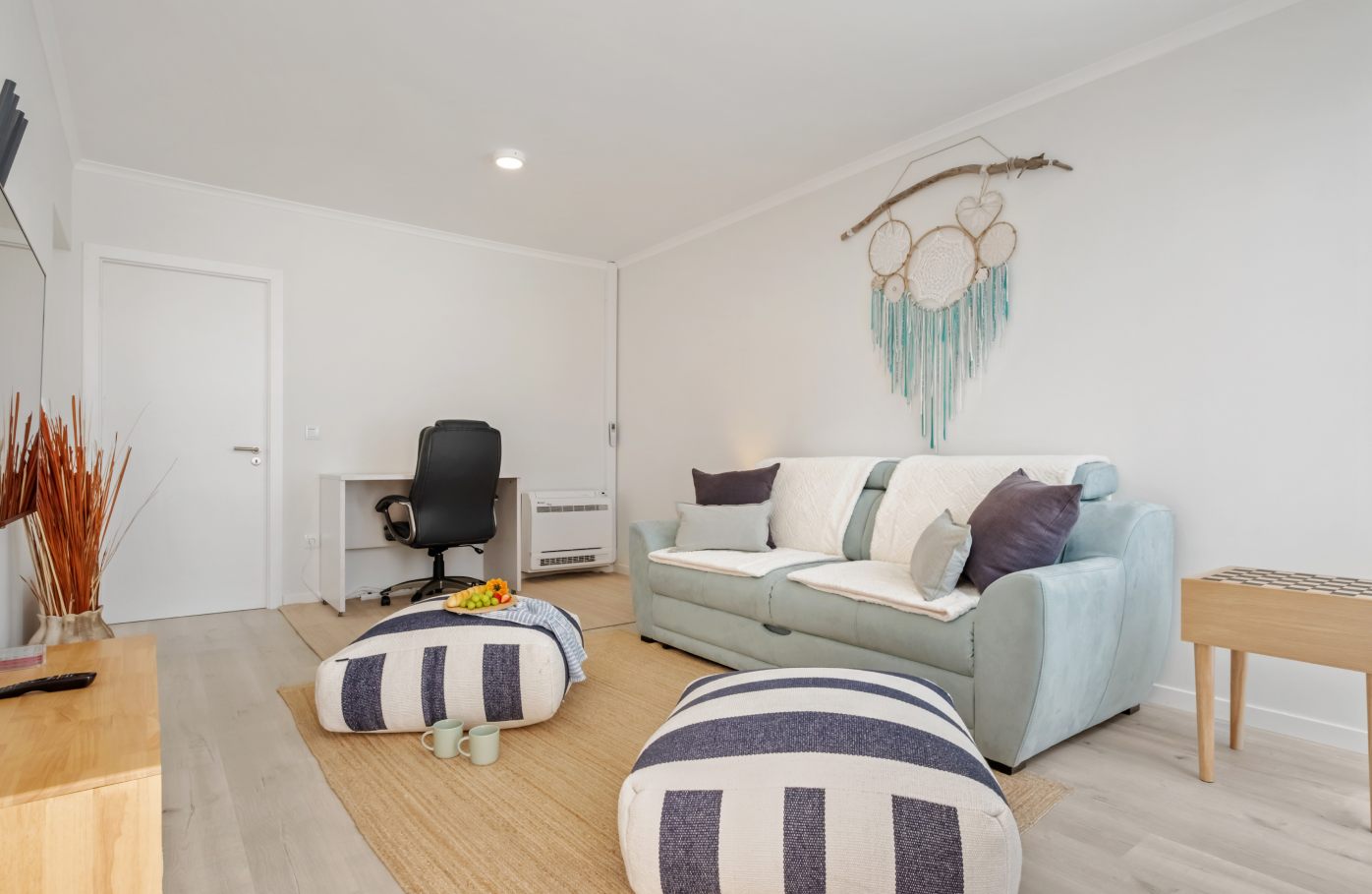 The loft office with a desk chair, a sofa and shelving